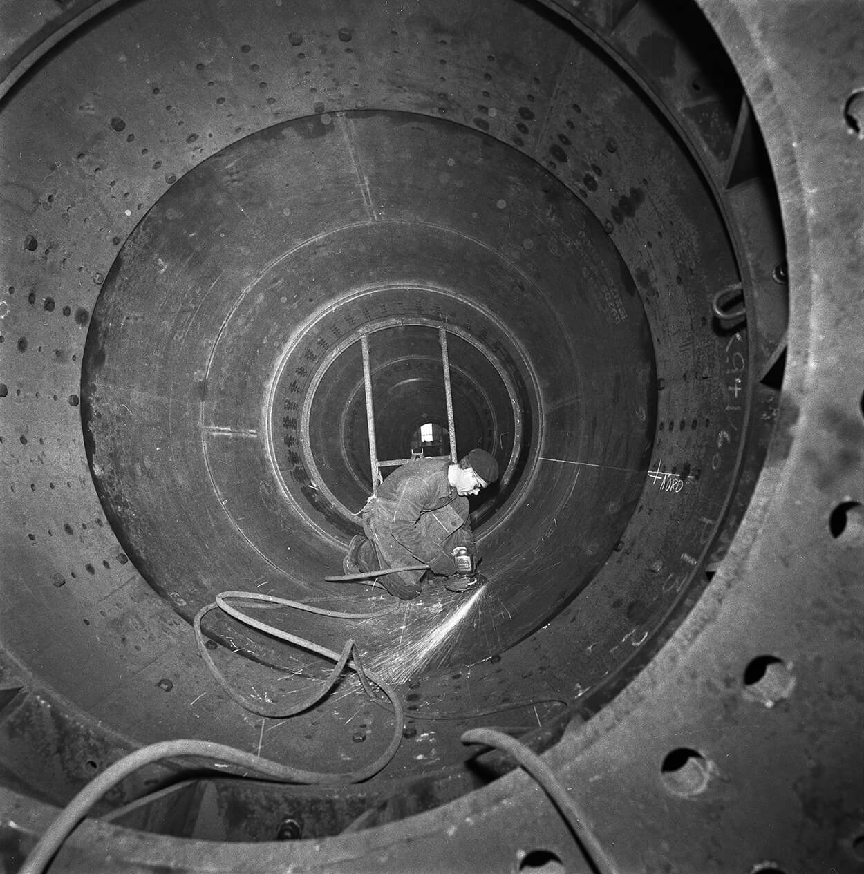 Arbeider på innsiden av Tryvannstårnet, hvor en vinkelsliper brukes under byggingen av den ikoniske betongkonstruksjonen